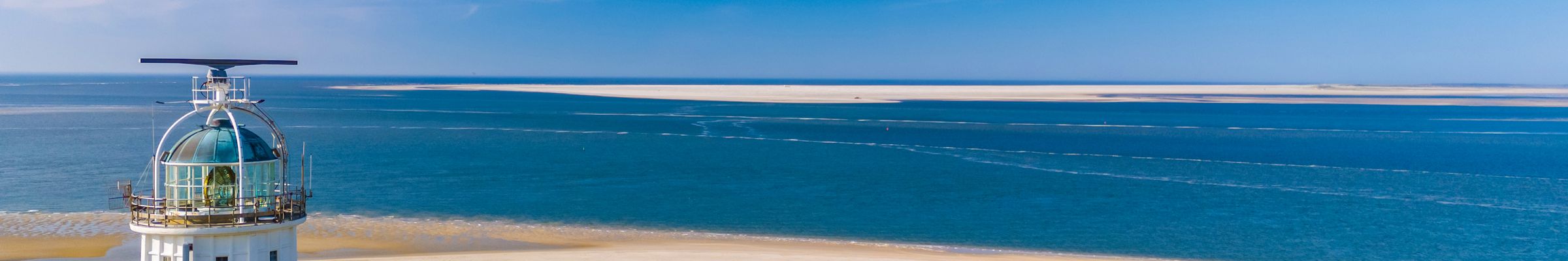 A lighthouse lantern overlooking a wide beach and open sea